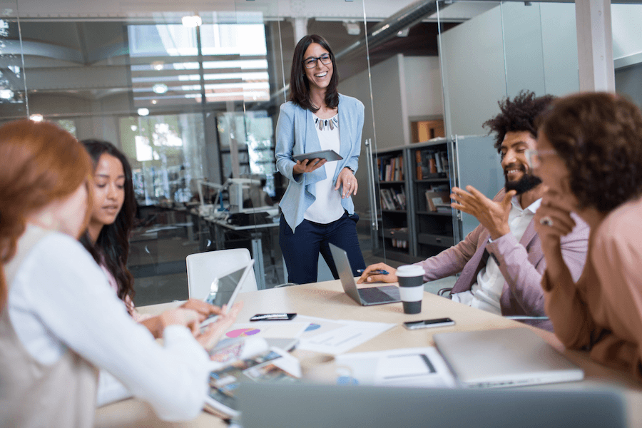 A woman improving employee experience through a presentation in a conference room.